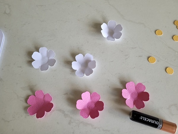 Flower embellishments pressed into shape with the end of a battery. 