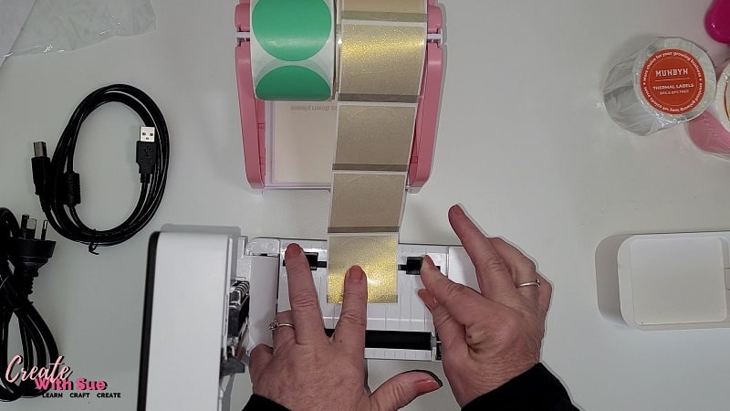 Adjusting the guides inside the Munbyn thermal printer to suit various label sizes. Setting shows a 2 inch translucent gold label. 