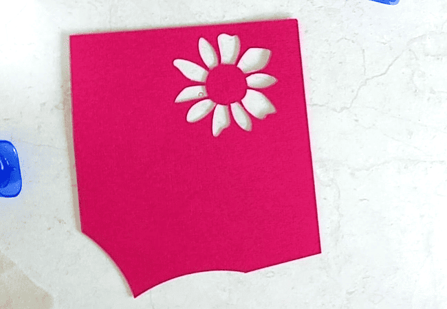 A piece of cardstock scap with a flower stencil in it. Super easy to use.